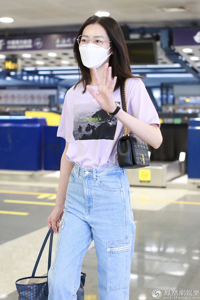 刘雯现身机场.刘雯身穿印花t恤搭配牛仔裤造型休闲.刘雯自己拎