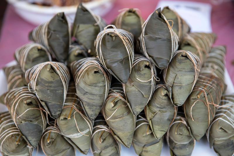 一名女师傅一边包网红黑毛猪肉粽,一边讲解包粽子的方法,引发了市民