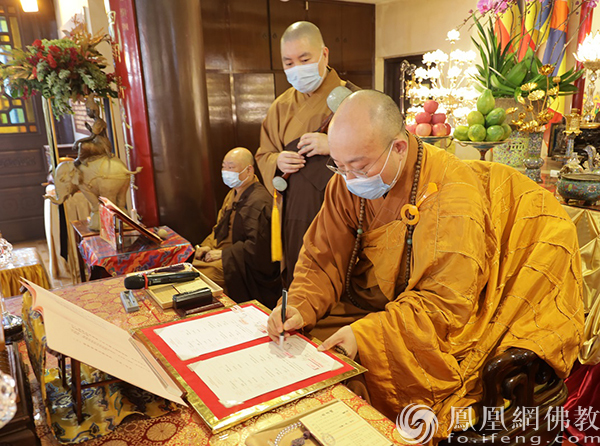 宏明大和尚签署证书(图片来源:凤凰网佛教 摄影:果亮)