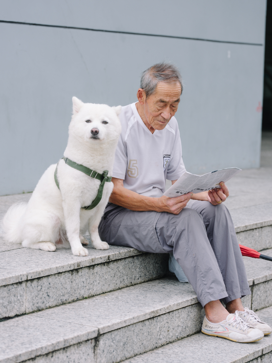 12号线爱国路站外,遛狗看报的老人今年79岁,年轻时在福建当过8年兵,后来进了十七棉当工人,退休后加入工友的足球俱乐部,每周两次,还去韩国提过比赛,拿了第一名。