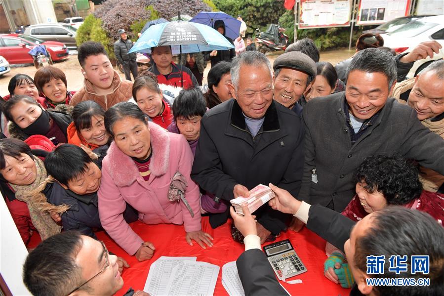 1月16日,在南昌市南昌县银湖管理处塔田村,村民们领取自己的分红.