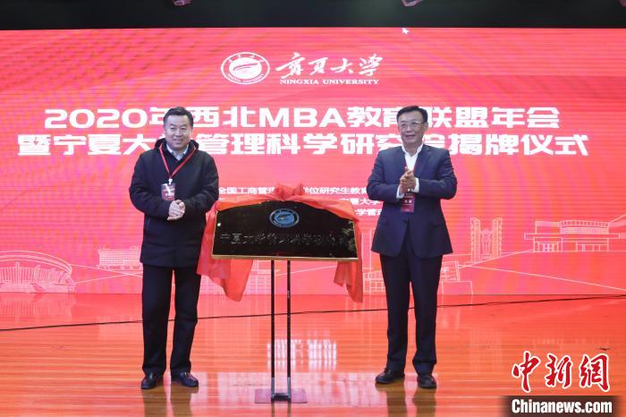 宁夏大学副校长李建设(左)和宁夏宝丰能源集团股份有限公司副总裁姚敏(右)为宁夏大学管理科学研究院揭牌。 苏雯 摄