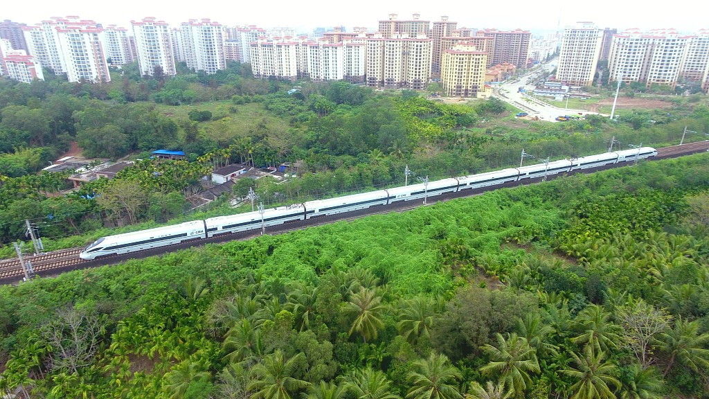 2020年3月17日,海南環島鐵路一列動車從春光明媚的瓊海城區經過.