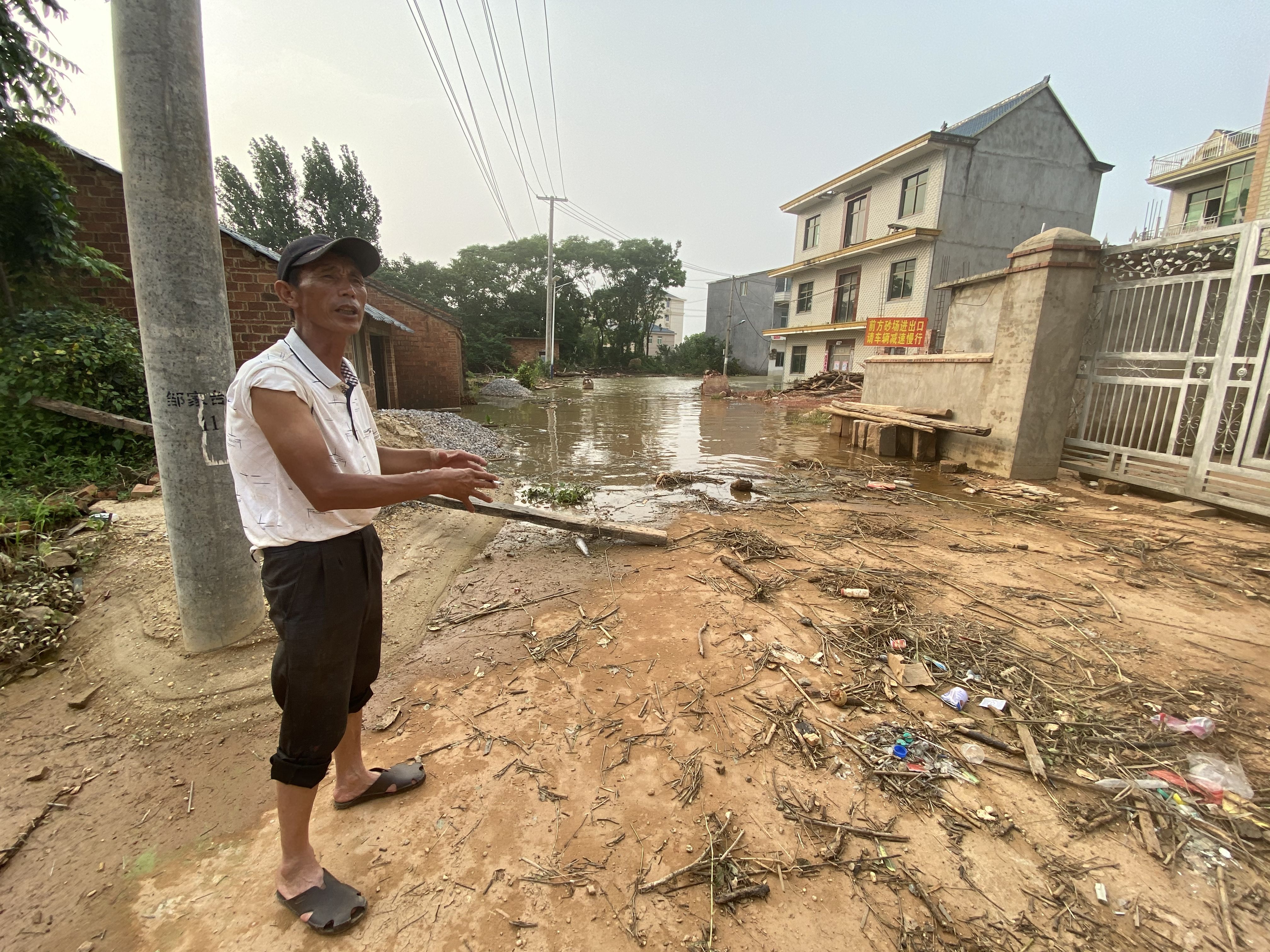 邹家村是龙口村三个自然村中受灾最严重的村庄，村民邹道喜在讲述洪水进村的场面。新京报记者 杜雯雯摄