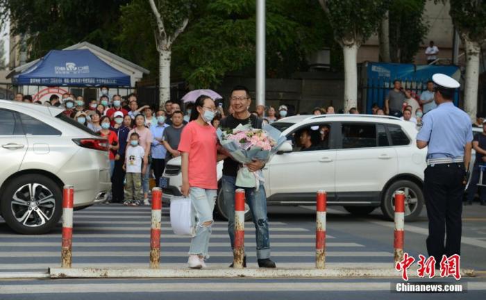 7月8日,内蒙古呼和浩特市一高考考点,考生结束考试后收到来自家长的鲜花。中新社记者 刘文华 摄