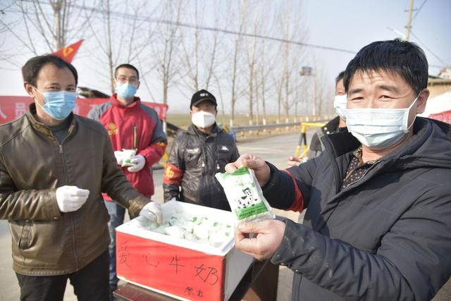 茌平區賈寨鎮賈寨後村疫情防控檢查點,值班人員賈天財(右)拿到張剛(左