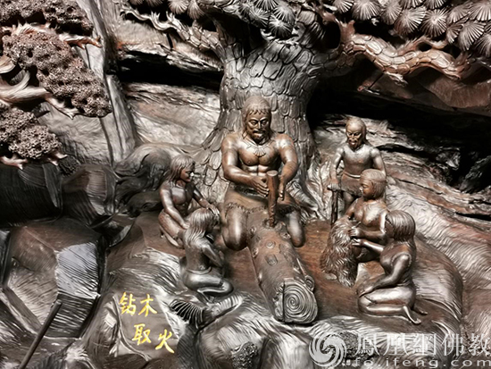 “中华上下五千年”巨型雕刻局部：钻木取火（图片来源：凤凰网佛教 桐柏山木雕博物馆提供）