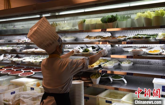 图为服务员正在整理菜品。 周毅 摄