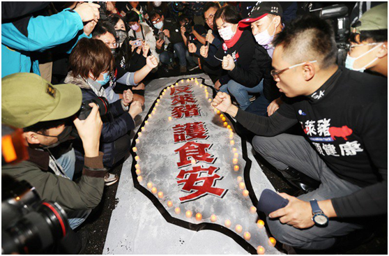 “反莱猪护食安”守夜活动23日晚在台“立法院”外举行，国民党主席江启臣带领党籍“立委”点灯，并将烛光放置在“反莱猪护食安”的台湾地图上。图自台湾“联合新闻网”