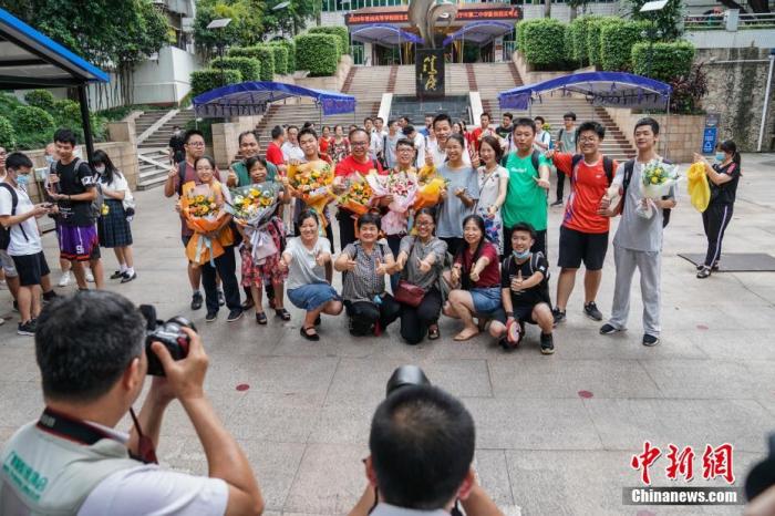 7月8日下午,广西南宁二中新民校区考点,高考英语科目考试结束后,老师与考生在考场外合影留念。中新社记者 陈冠言 摄