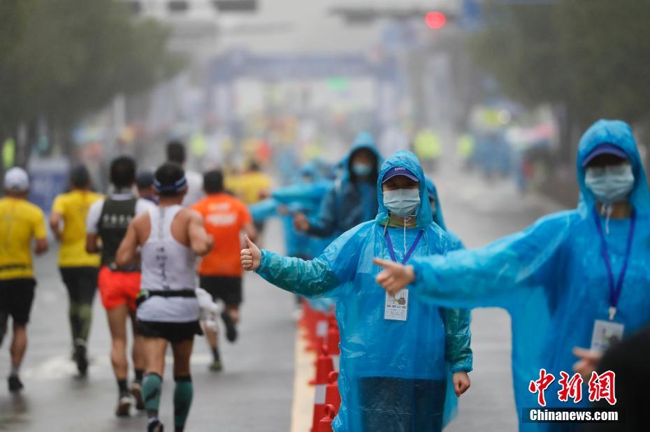 图为志愿者戴口罩为选手加油点赞。 中新社记者 杜洋 摄