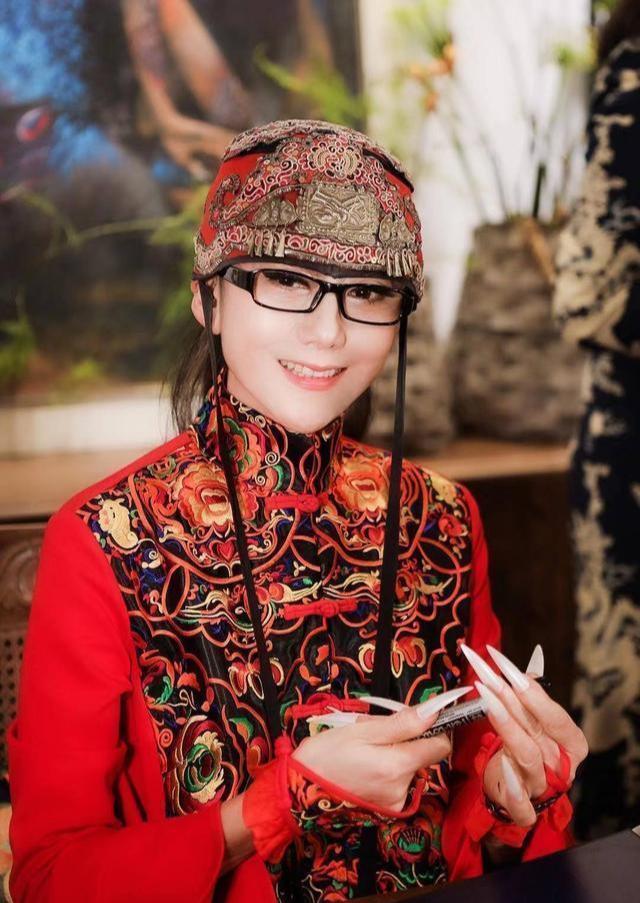 61岁杨丽萍近照曝光,穿东北大花裙在花园摆拍,3cm长指甲太吸睛