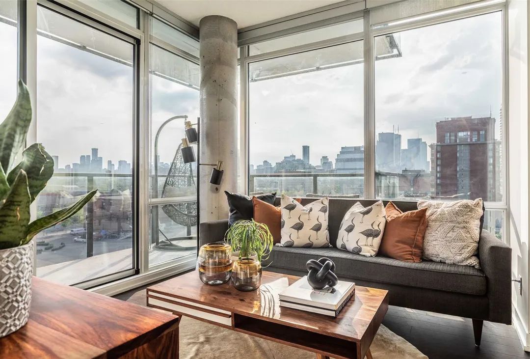 客厅有着双面采光的大落地窗,窗外是现代化的都市风光,无遮挡的大