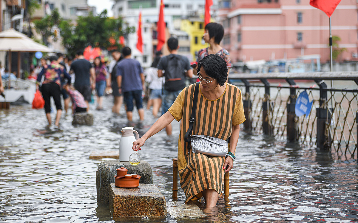 10月19日,天文大潮期间,厦门沙坡尾水位上涨,市民坐在水中悠闲喝茶。每年农历9月,厦门岛都会出现天文大潮。受其影响,这两天厦门一些沿海低洼地段出现了海水倒灌、漫堤的现象。据国家海洋局厦门海洋预报台监测,厦门海域最高潮位出现在18日中午,达到720厘米,超过蓝色警戒潮位。林铭鸿/人民视觉 图