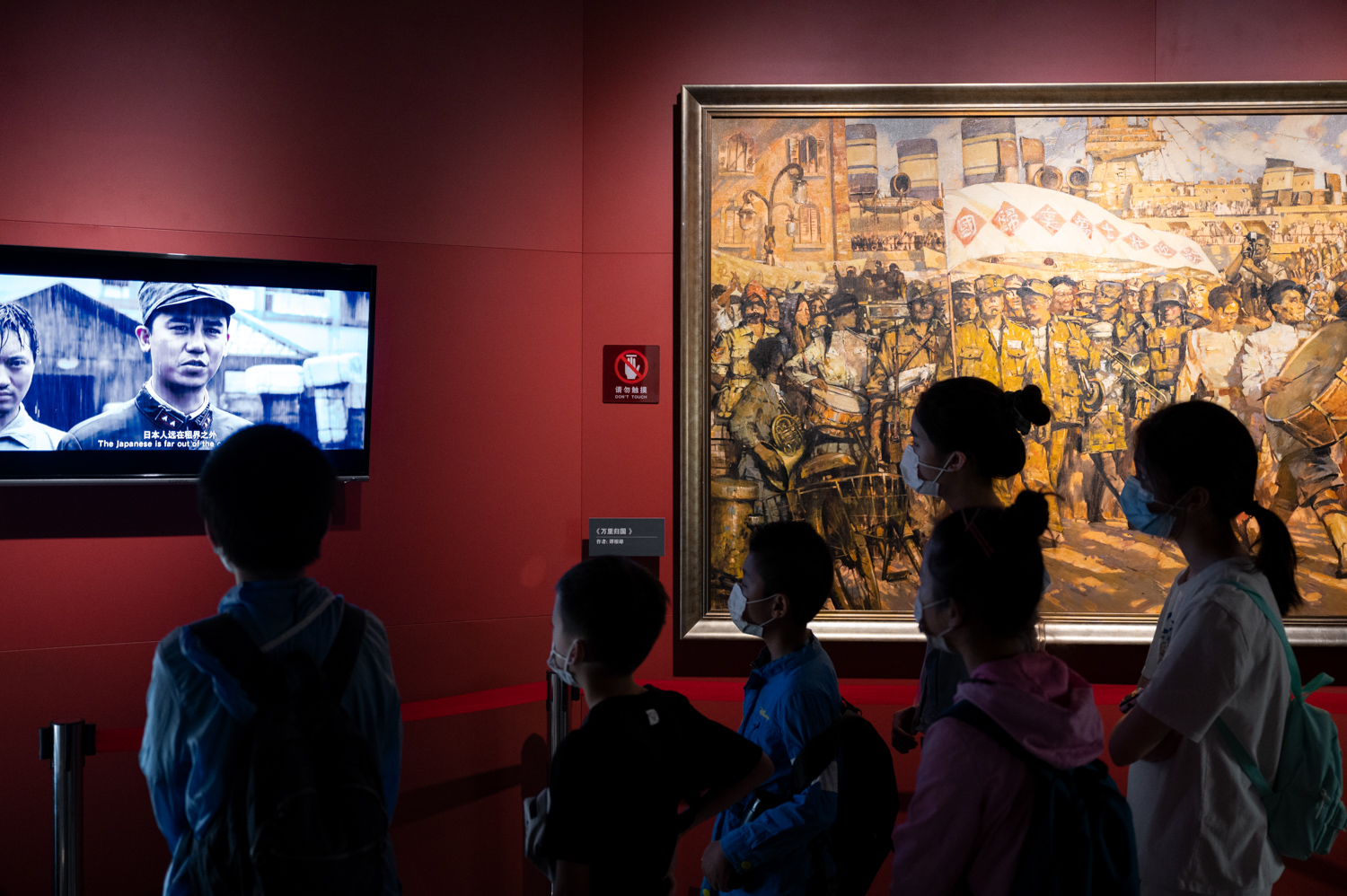 展厅内前来参观的游客正在观看屏幕上播放的相关短片。