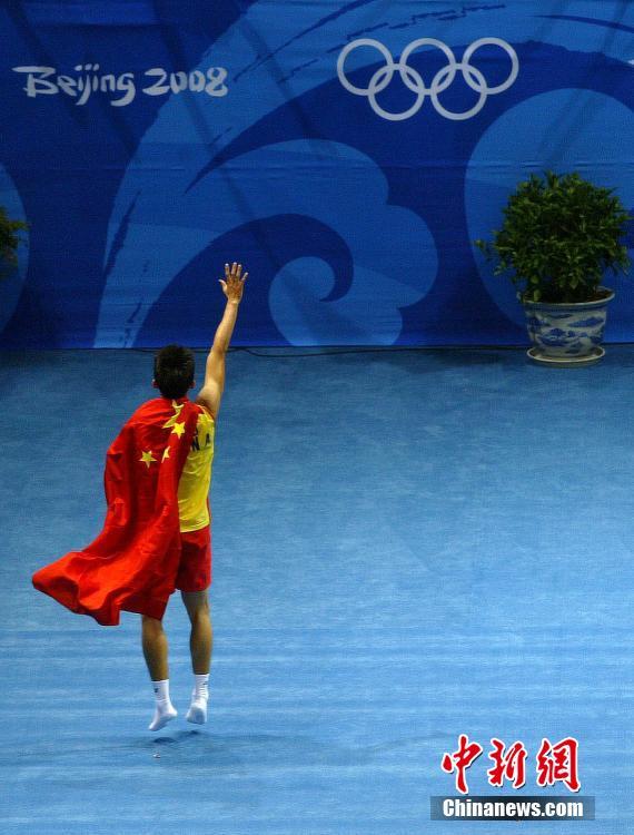 2008年8月17日，北京工业大学体育馆，2008北京奥运会，羽毛球男单决赛，林丹获得男单冠军后披国旗庆祝。图片来源：视觉中国