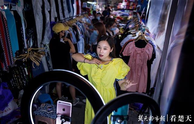 江汉路上的地摊主一边摆地摊一边直播，图片来源：楚天都市报