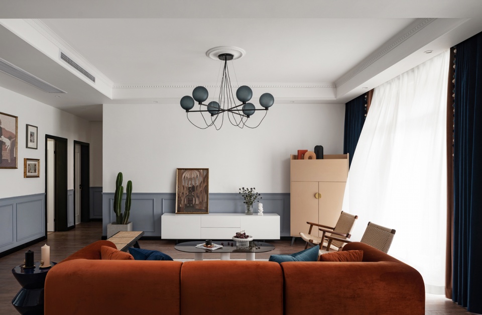 客厅窗帘选用砖橙色和复古深蓝相搭配,与沙发的颜色相呼应,使得空间