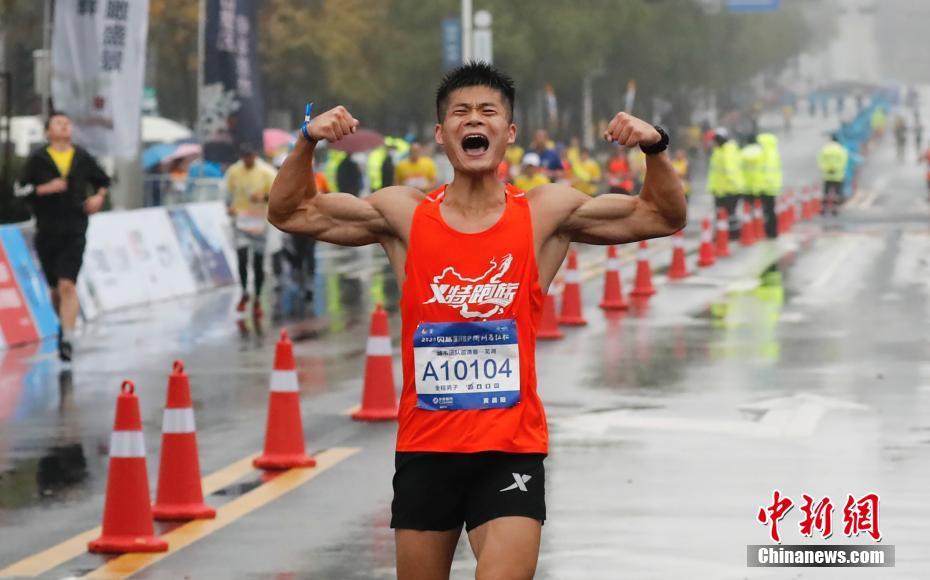 图为一名参加全程比赛的选手冲过终点线。 中新社记者 杜洋 摄
