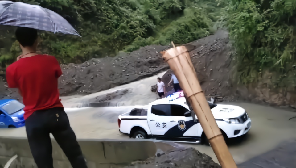 大雨倾盆面包车被困山洪中，民警趟水系绳索拖车救援
