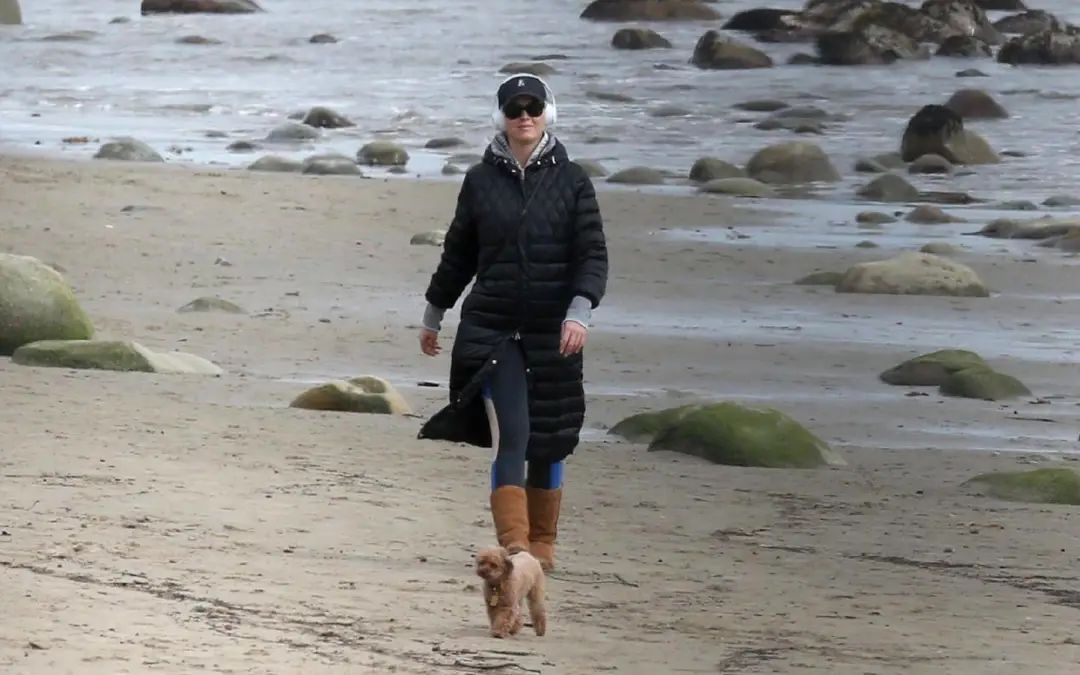 水果姐抱爱宠海边散步长款羽绒服巧遮孕肚穿健美裤暴露大象腿