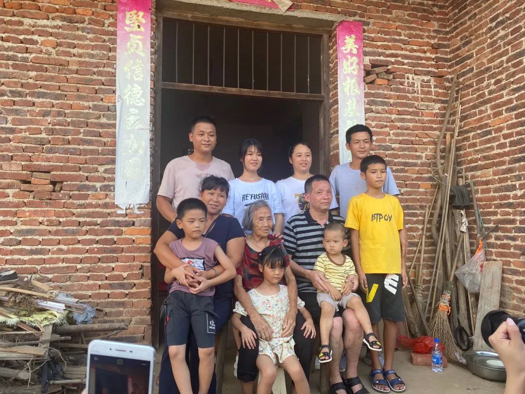 8月7日下午，时隔27年，张玉环一家12口人在家门口拍摄全家福合影。新京报记者杜雯雯 摄