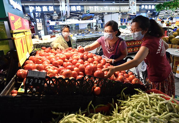 家乐福超市，顾客正在选购西红柿。