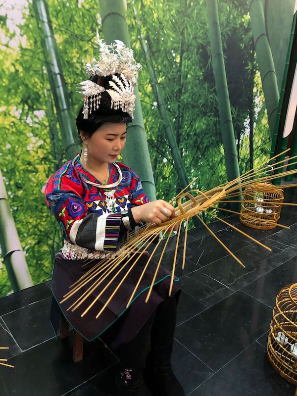 贵州省丹寨县万达小镇非遗展示馆，非遗传承人在展示鸟笼制作技艺。