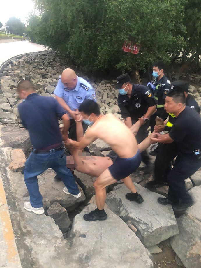 众人合力将轻生男子抬到附近平整地面。宝安警方 供图