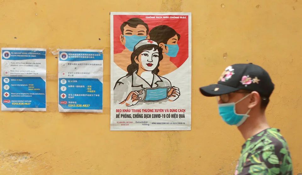 (图说:疫情期间越南街头张贴的佩戴口罩宣传画.来源/美联社)