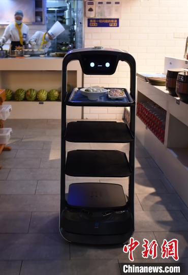 图为机器人服务员前往送菜。 周毅 摄