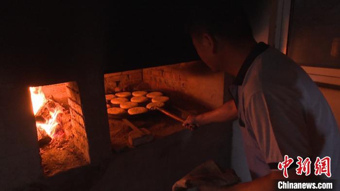 9月26日,在安徽省黄山市祁门县新安镇的一个手工作坊里,负责烘烤的师傅正在烤制徽州麻饼。 刘鸿鹤 摄