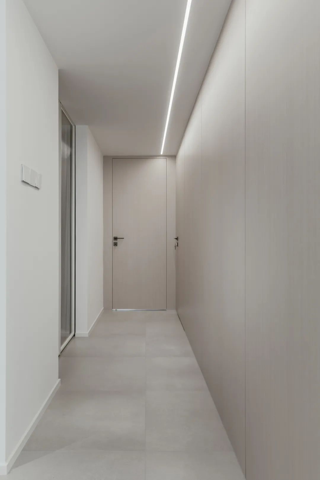 走廊在极简的木饰面空间基础,房门与墙面融为一体的简洁设计,显得