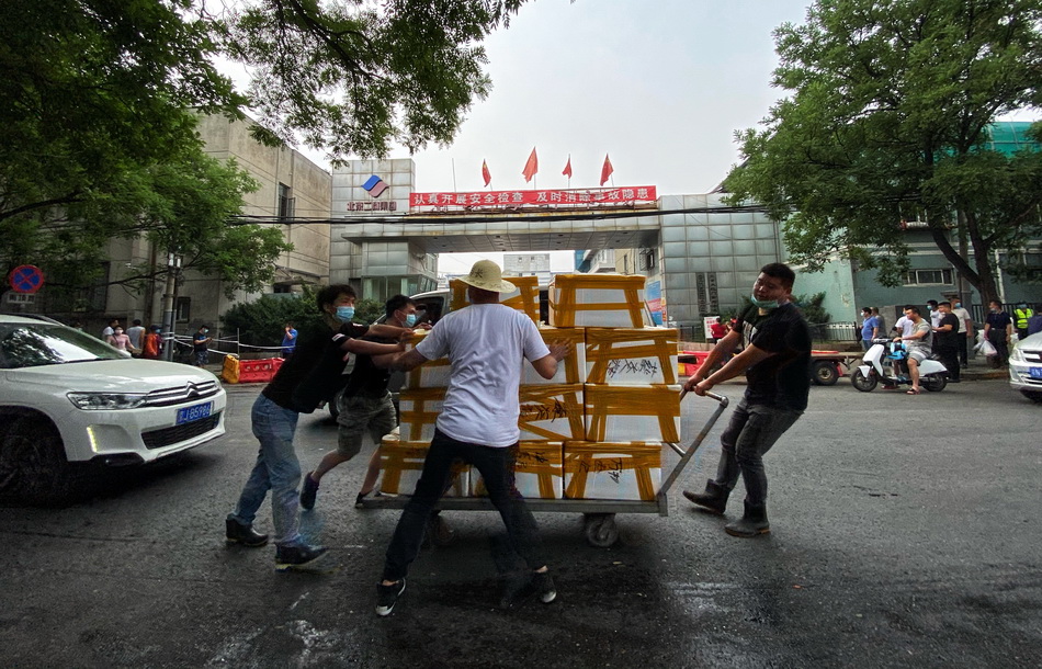 6月13日，北京京深海鲜市场门前贴出暂停营业的告示，大批商户正在有序撤走市场内的生鲜产品。人民视觉 图