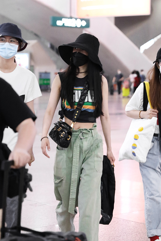 照片中杨幂跟随行的工作人员一同现身机场,军绿色的阔筒裤搭配了黑色