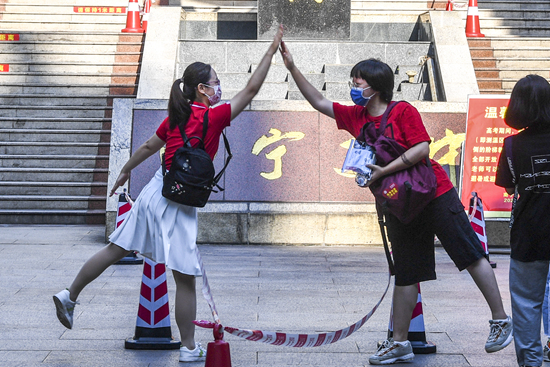 6月7日，2021年高考拉开帷幕。在广西南宁市第二中学新民校区考点，老师（左）与考生击掌。新华社记者 曹祎铭/摄