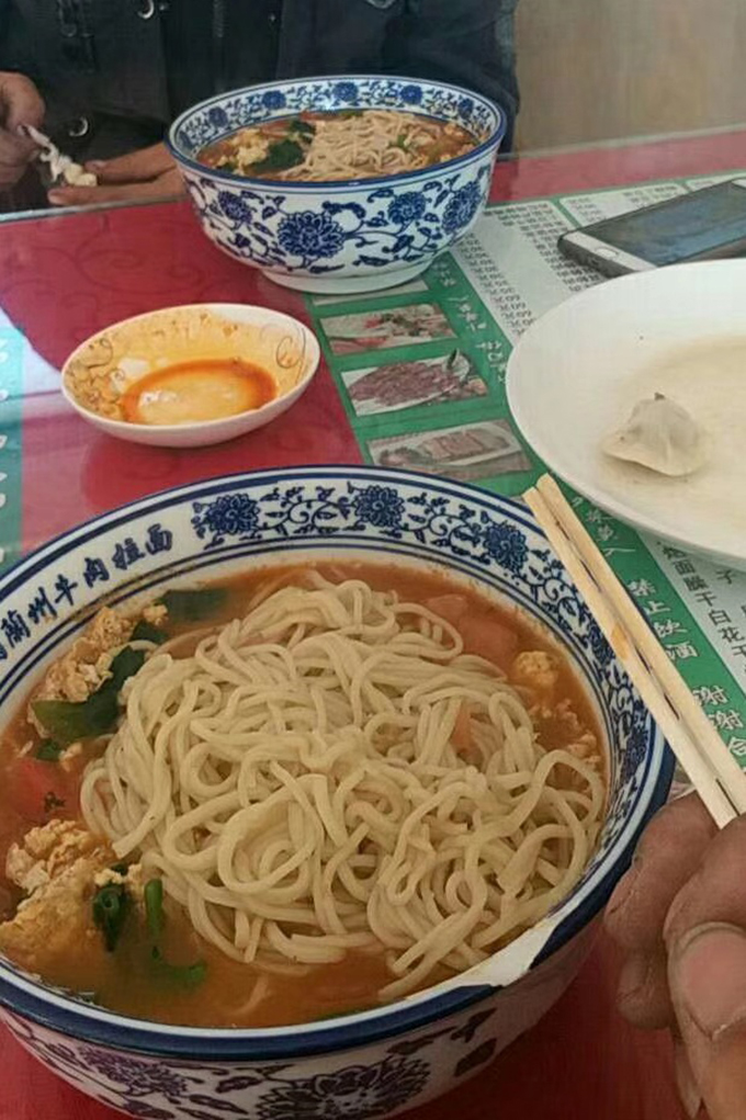 刘坤荣和朋友在开车途中吃生日面。 受访者供图