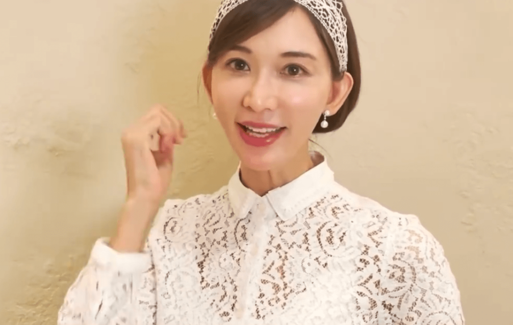 画面中,林志玲身穿一袭蕾丝白裙,带着小巧的珍珠耳饰,头上搭配同款