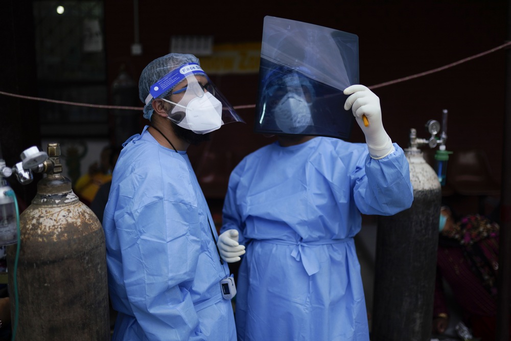 当地时间2021年5月18日,尼泊尔加德满都,医护人员查看新冠患者的X光报告。