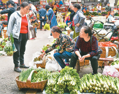 乘坐5630次列车来到桐梓县的村民在卖菜。