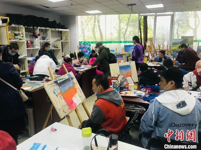 五彩梦想画室内，坐满了前来绘画的心智障碍者。 岳依桐 摄