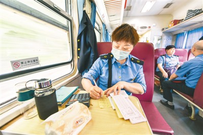 乘务员在列车上登记乘车信息。