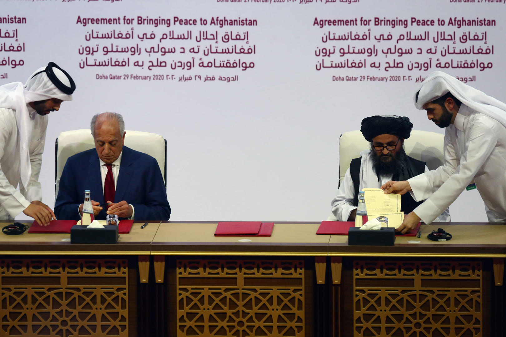↑2020年2月29日，卡塔尔多哈，巴拉达尔与美国阿富汗和平特使扎勒米·哈利勒扎德签署协议。图据路透社