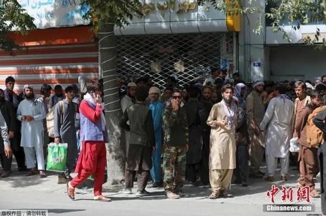 资料图：当地时间8月15日，阿富汗首都喀布尔，民众在银行外排队取钱。阿富汗塔利班发言人当天宣布，塔利班武装人员已进入首都喀布尔
