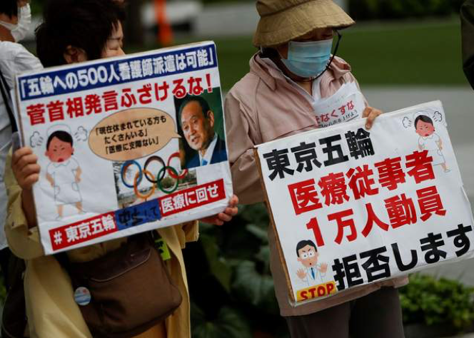 5月18日,东京奥委会大楼外,日本民众举起标语抗议举办奥运会
