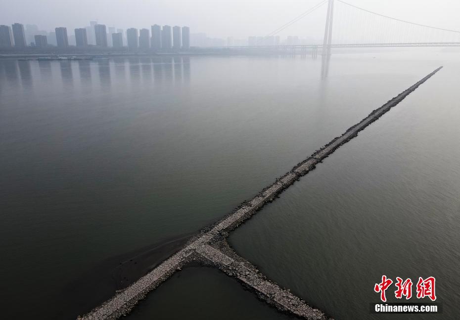  2月3日，武汉市鹦鹉洲大桥与杨泗港大桥之间的长江水域，江面正中间出现了一条细长的“石子路”，将长江水道一分为二，绵延2公里长左右，其间还有几条岔道。据了解，这是航道整治的建筑物——丁字坝。因该处附近江面较宽，为了让江水集中利于行船，丁字坝起到了束水的作用。其作用在于整治航道，优化通航环境。因近期江水退落的原因，该建筑物部分显露在江面上。 图片来源：视觉中国