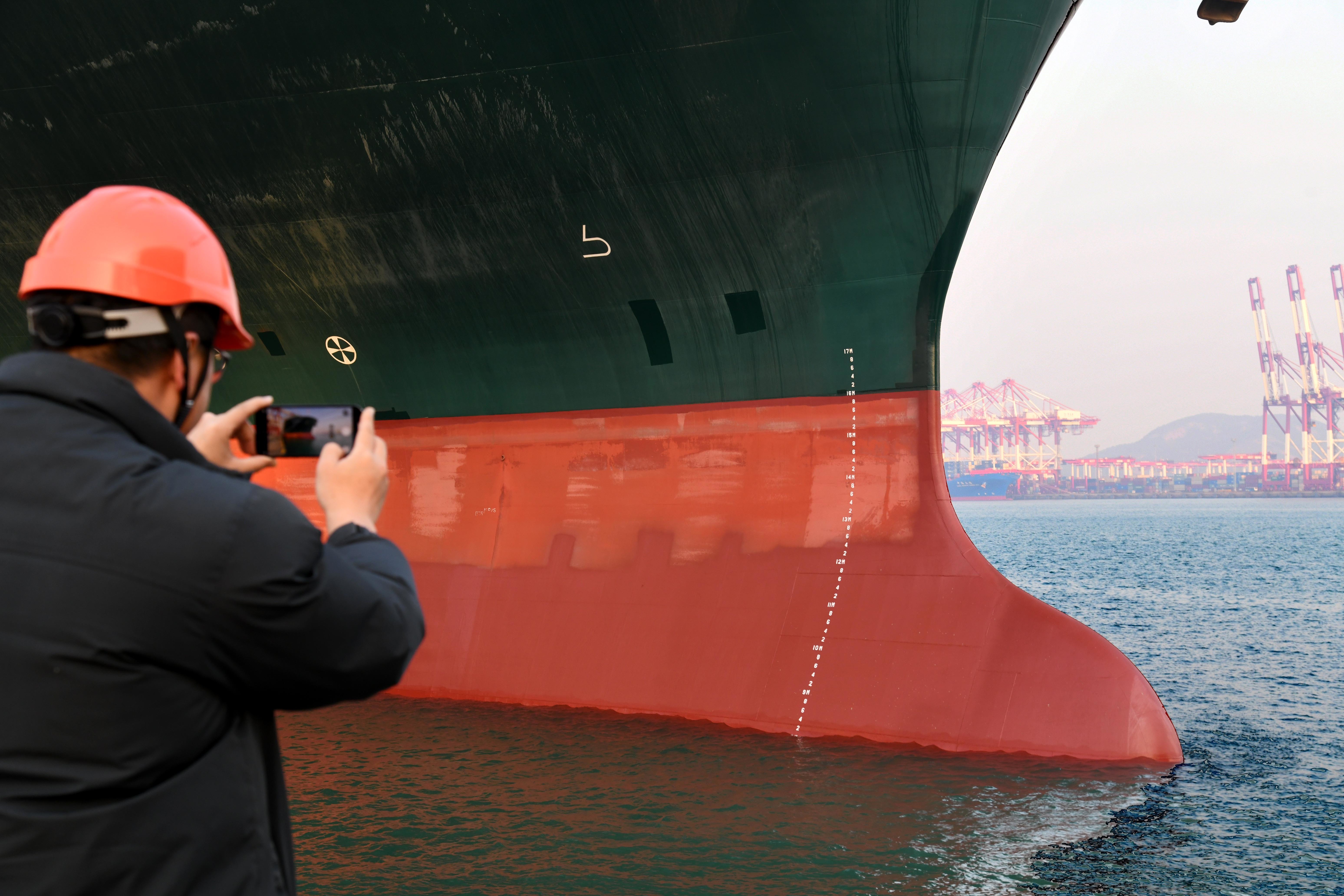 11月13日，一名工作人员在拍摄“长赐”号货轮。新华社记者 李紫恒 摄