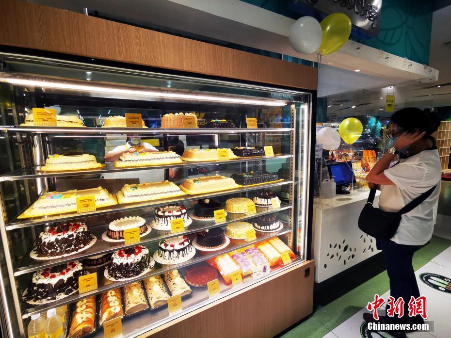 当地时间5月16日,菲律宾首都马尼拉CBD马卡蒂LANDMARK大型生活超市,手工制作蛋糕摊档,货品琳琅满目,市民戴着口罩和面罩在采购。从5月15日至31日,首都大马尼拉地区及邻近4省布拉干、甲米地、拉古那、黎刹(NCR Plus)以及其他一些地区,防疫隔离分类从“修订版加强社区隔离”降为更宽松的“一般社区隔离” 。封城”降级”的第一个周末,马尼拉商业恢复迅速。 中新社记者 关向东 摄
