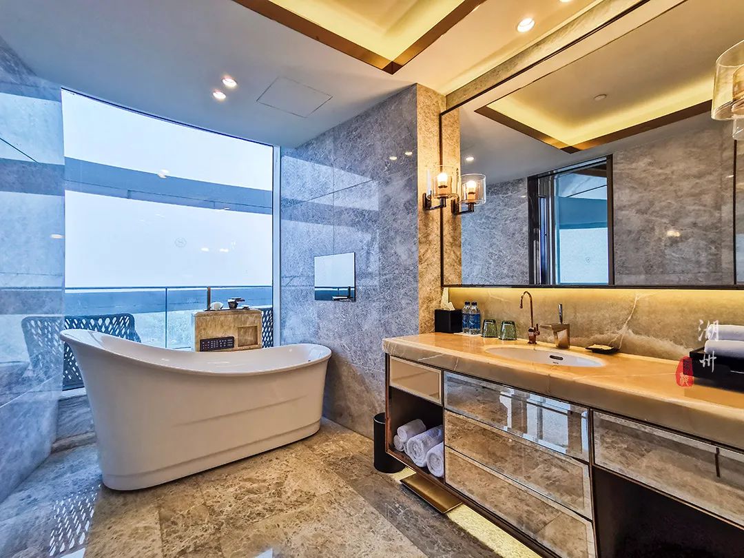 卫生间的浴缸旁边就是大块的落地玻璃窗,你可以一边泡澡一边欣赏窗外