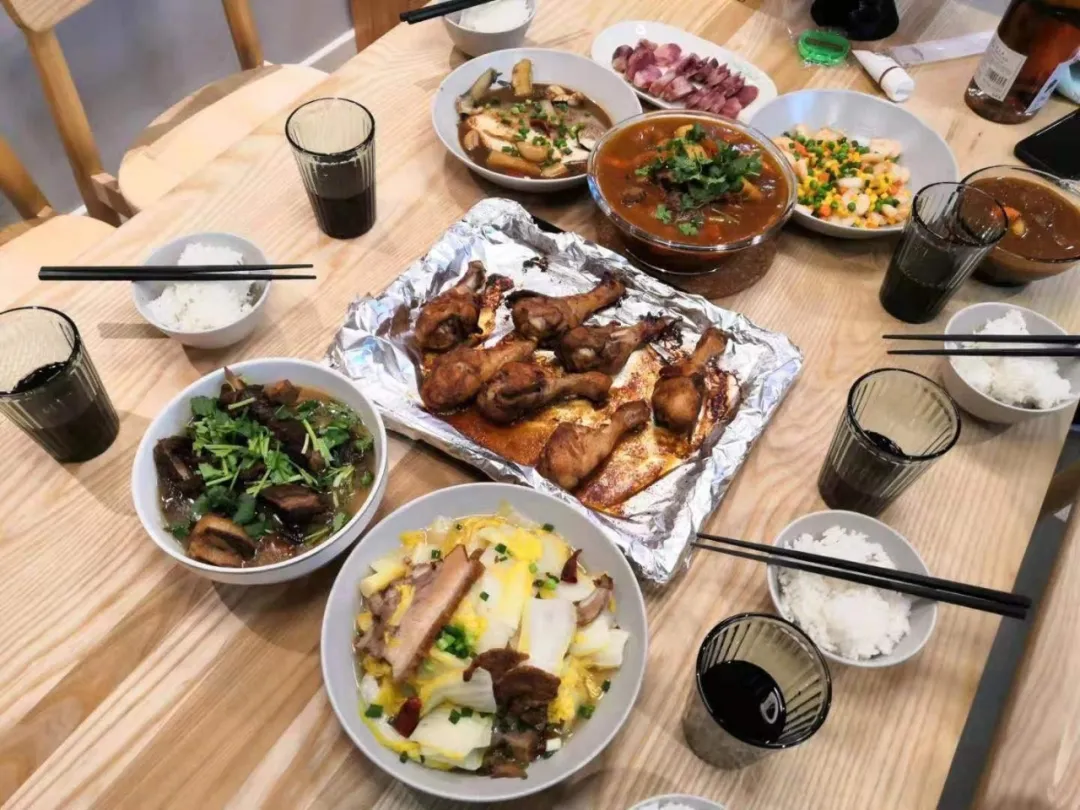 (↑ 邓欣和同事们的搭伙年夜饭)她和朋友们推杯置盏,边吃饭边唠家常